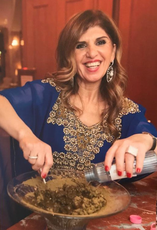 A woman adding salt to food she is preparing